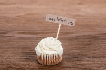 tasty cupcake with Happy fathers day inscription on wooden surfaceの写真素材