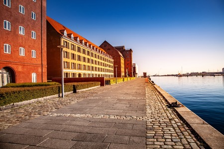 empty embankment near harbor and buildings at sunny day, copenhagen, denmarkの写真素材