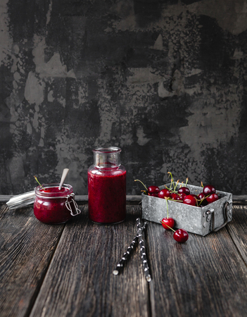 Fresh healthy smoothie on rustic table with cherries and strawsの写真素材