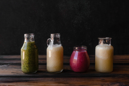 Set of bottles with fresh healthy smoothies on rustic tableの写真素材