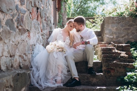 bride and groom sitting on stairs at old townの写真素材