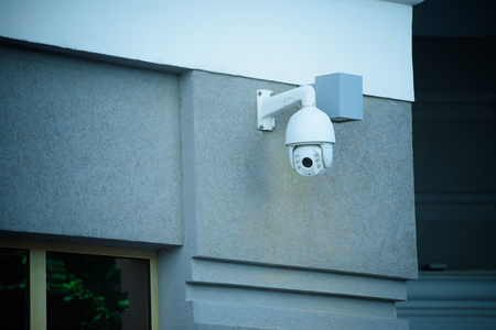 close up view of security camera on gray building facade