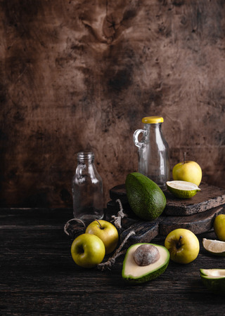 Glass bottles and fruit ingredients for smoothie on rustic wooden boardの写真素材