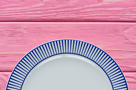 top view of empty round plate on pink wooden table topの写真素材