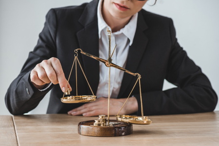 cropped image of business adviser putting precision weights on scales in officeの写真素材