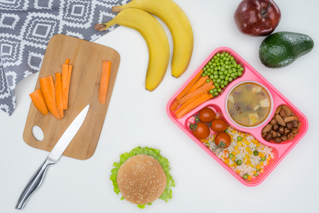 top view of tray with kids lunch for school and cutting board isolated on whiteの写真素材