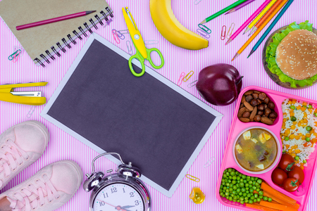 top view of blackboard and tray with kids lunch for school on purple tabletopの写真素材