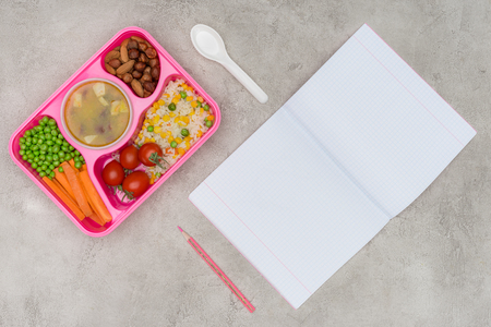 top view of tray with kids lunch for school and open notebook on marble tableの写真素材