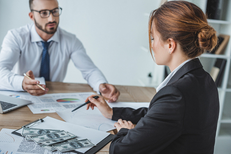 financiers pointing on documents at table in officeの写真素材