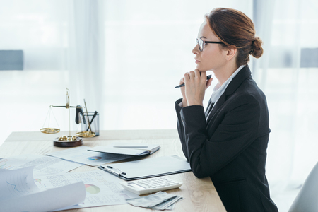 side view of financier sitting at table in officeの写真素材