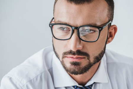 portrait of handsome businessman in glasses looking away isolated on whiteの写真素材