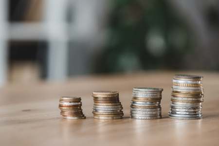 Stacks of coins on wooden tabletop in financial office