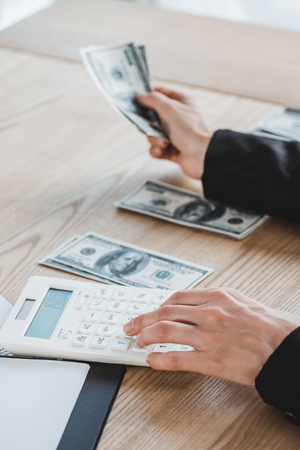 cropped image of business adviser calculating dollars in officeの写真素材
