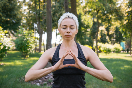 woman meditating with closed eyes in parkの写真素材