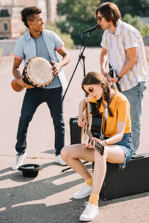Young and happy multiracial male and female street musicians in cityの写真素材