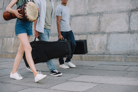 Cropped view of young people in band walking and carrying musical instrumentsの写真素材