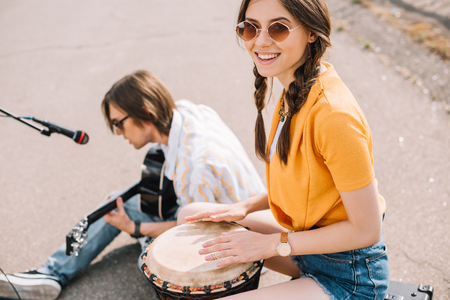 Couple of young street musicians smiling and performing in urban environmentの写真素材