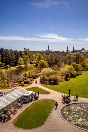 COPENHAGEN, DENMARK - MAY 6, 2018: aerial view of trees and pond in park and people sitting at tables in Copenhagen, Denmarkのeditorial素材