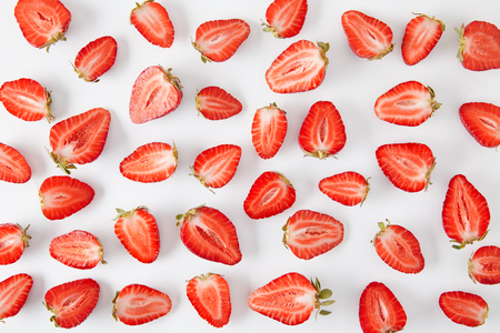 top view of arranged fresh strawberries pieces isolated on whiteの写真素材