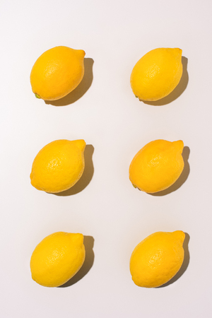 top view of arranged lemons in rows on white tableの写真素材