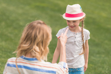 beautiful happy mother and daughter looking at each other in parkの写真素材