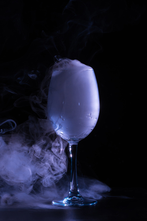 wineglass with grey smoke on black backgroundの写真素材