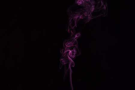 black background with spiritual pink smoky swirlの写真素材