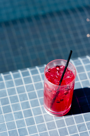 close-up shot of glass of delicious berry cocktail on poolsideの写真素材