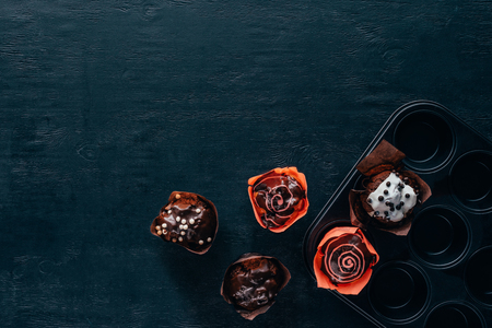 top view of delicious muffins with glaze in baking pan on wooden backgroundの写真素材