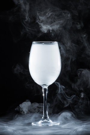 wineglass with white smoke on black backgroundの写真素材