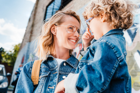 happy mother and son looking at each other on streetの写真素材
