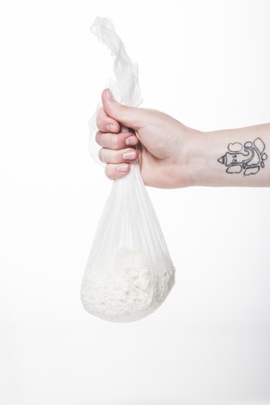 cropped shot of woman holding cheesecloth sack with cottage cheese isolated on whiteの写真素材