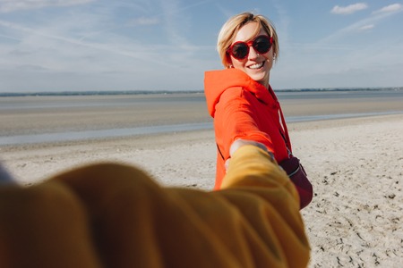 friends holding hands sandy beach, Saint michaels mount, Normandy, France