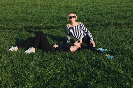 attractive young women relaxing on green grass in parkの写真素材