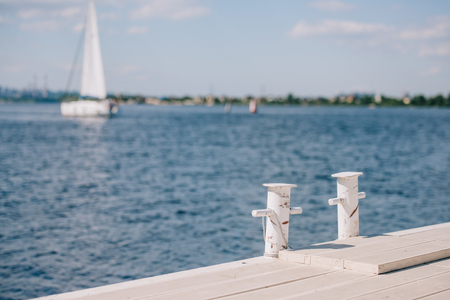 empty wooden pier and yacht on background at summer dayの写真素材