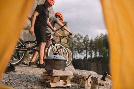 view of young trial bikers on rocky cliff outdoors from camping tentの写真素材