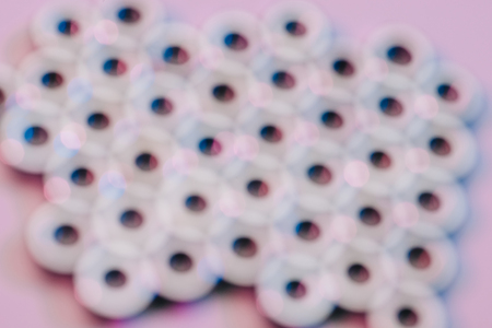 selective focus of screw nuts on pink surface