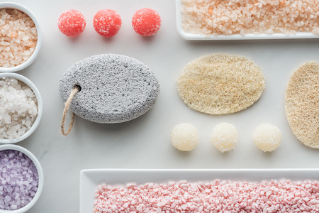 top view of various sea salt, sponges and handmade soap on whiteの写真素材