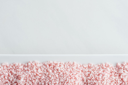 top view of pink sea salt on white background