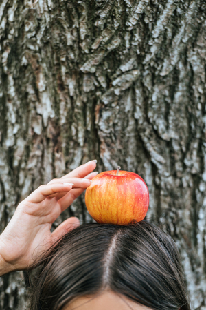 partial view of girl holding with apple on headの写真素材
