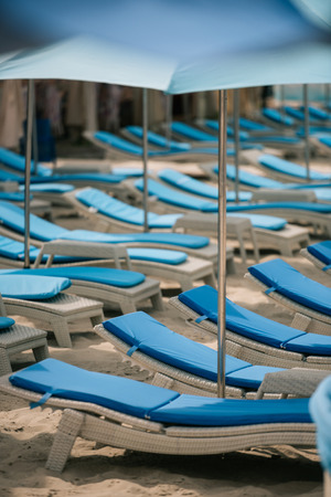 empty chaise lounges and umbrellas at beachの写真素材