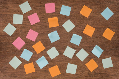 top view of arranged colorful post it notes on wooden table
