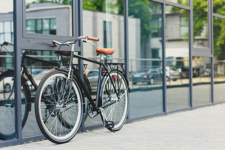 comfortable bicycle reflected in modern building on empty streetの写真素材