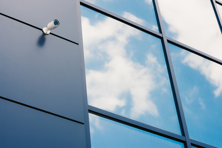 Glass facade of modern office building with security cameraの写真素材
