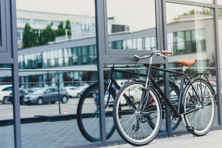 stylish bicycle reflected in modern building on empty streetの写真素材