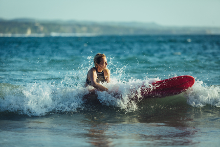 attractive caucasian sportswoman sitting on surfboard in seaの写真素材