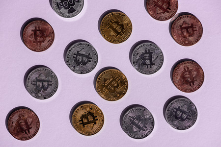 top view of various arranged bitcoins on purple background