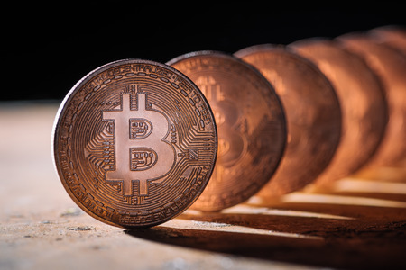close up view of arranged bitcoins on black backdrop