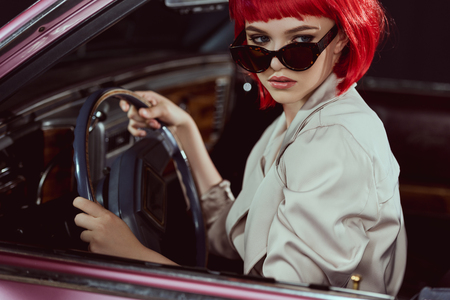beautiful stylish girl in sunglasses driving retro carの写真素材