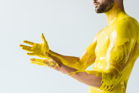 Handsome bearded man stained with yellow liquid isolated on white backgroundの写真素材